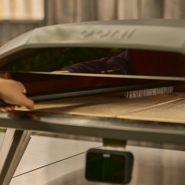 long pizza oven brush being used in koda 2 max pizza oven