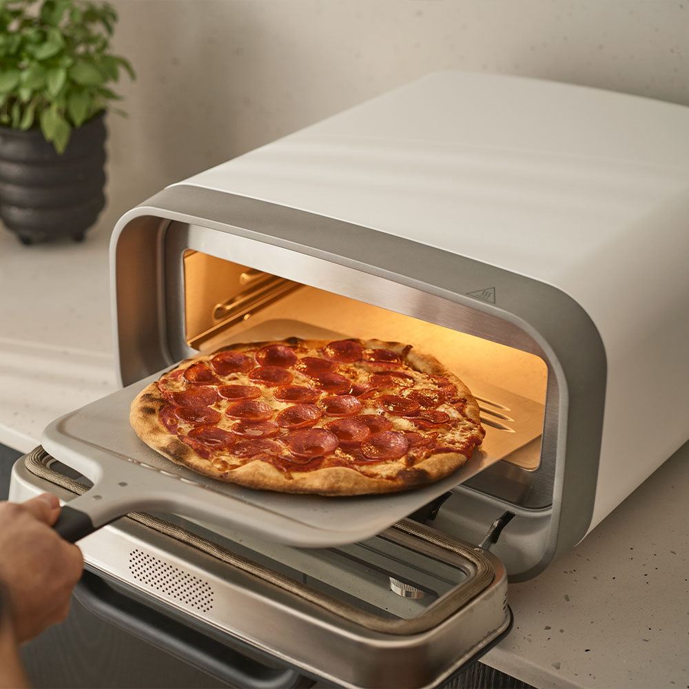 Volt 2 Electric Pizza oven, with pizza and peel. Oven in Polar White. 